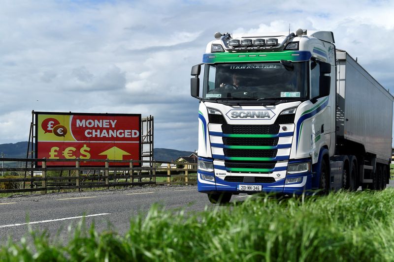 © Reuters. FILE PHOTO: A truck drives past a 'money changed' sign for euro, sterling and dollar currencies on the border between Northern Ireland and Ireland, in Jonesborough, Northern Ireland, May 19, 2022. REUTERS/Clodagh Kilcoyne/File Photo