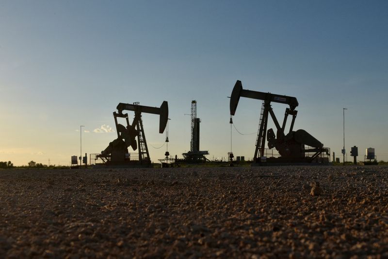 © Reuters. FILE PHOTO: Pump jacks operate in front of a drilling rig in an oil field in Midland, Texas U.S. August 22, 2018. REUTERS/Nick Oxford