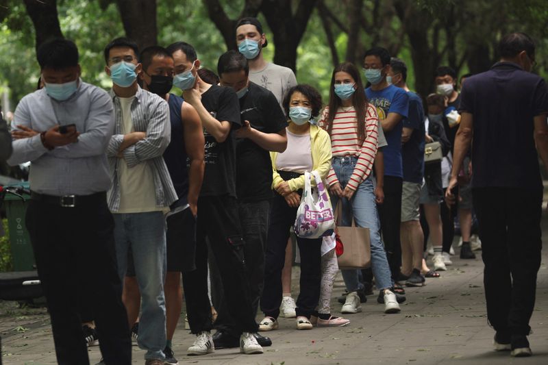 &copy; Reuters. People line up for nucleic acid tests at a mobile testing booth, following the coronavirus disease (COVID-19) outbreak, in Beijing, China June 13, 2022. REUTERS/Tingshu Wang