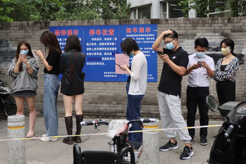 &copy; Reuters. Gente hace cola para someterse a una prueba de ácido nucleico en un puesto de pruebas móvil, tras el brote de la enfermedad por coronavirus (COVID-19), en Pekín, China. 13 de junio de 2022. REUTERS/Tingshu Wang
