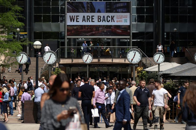 © Reuters. FILE PHOTO: People walk through the financial district of Canary Wharf as it was announced that British consumer price inflation hit an annual rate of 9.0% in April, in London, Britain, May 18, 2022.     REUTERS/Kevin Coombs