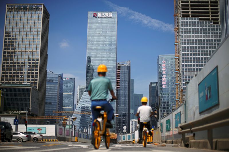 &copy; Reuters. FILE PHOTO: Men ride bicycles past construction sites in Shenzhen, Guangdong province, China September 26, 2021. REUTERS/Aly Song/File Photo