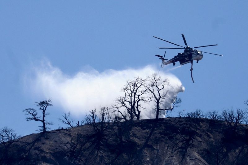 © Reuters. A helicopter assists firefighters battling the Sheep Fire wildfire, in Wrightwood California, U.S., June 13, 2022. REUTERS/David Swanson