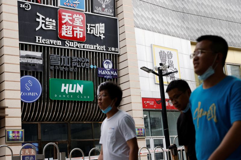 © Reuters. People walk past a sign of the Heaven Supermarket bar, where a coronavirus disease (COVID-19) outbreak emerged, in Chaoyang district of Beijing, China June 13, 2022. REUTERS/Carlos Garcia Rawlins