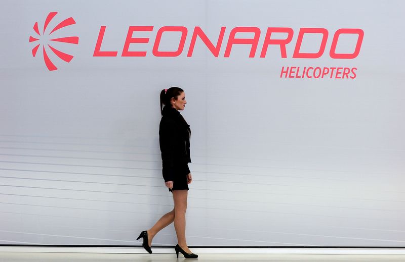 &copy; Reuters. FILE PHOTO: A hostess walks past a Leonardo's helicopter logo at the headquarters in Vergiate, near Milan, Italy, January 30, 2018. REUTERS/Massimo Pinca