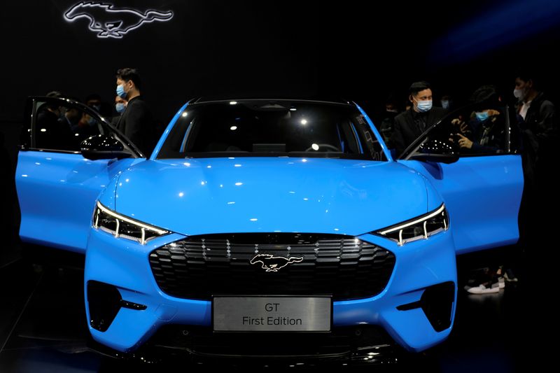 © Reuters. FILE PHOTO: Visitors check on a Ford Mustang Mach-E electric vehicle displayed at a launch event in Shanghai, China April 13, 2021. REUTERS/Yilei Sun/File Photo