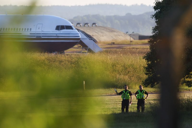 &copy; Reuters. Police officers stand near a plane reported by British media to be first to transport migrants to Rwanda at MOD Boscombe Down base in Wiltshire, Britain, June 14, 2022. REUTERS/Hannah McKay