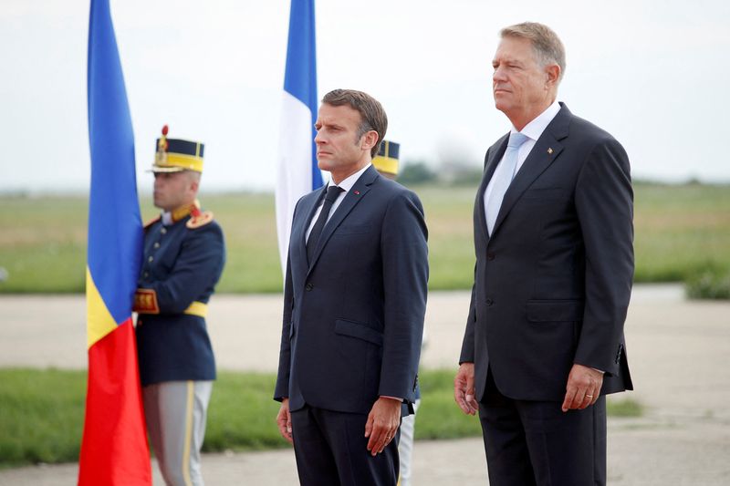 &copy; Reuters. French President Emmanuel Macron and Romanian President Klaus Iohannis stand for the national anthem during a welcome ceremony ahead of their meeting at the Mihail Kogalniceanu Air Base, near the city of Constanta, Romania  June 15, 2022. Yoan Valat/Pool 