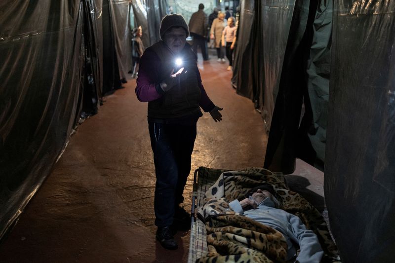 &copy; Reuters. FOTO DE ARCHIVO: Una mujer al lado de otra tumbada en su cama dentro del refugio antibombas de la planta química de Azot, donde la gente se esconde de los bombardeos desde el comienzo de la guerra, en Sievierodonetsk, región de Luhansk, Ucrania, el 16 d