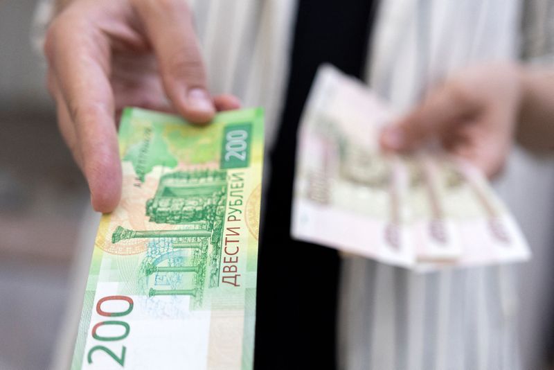 © Reuters. FILE PHOTO: Woman holds Russian Rouble banknotes in this illustration taken May 30, 2022. REUTERS/Dado Ruvic/Illustration