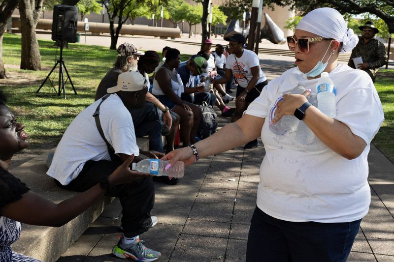 &copy; Reuters. FILE PHOTO: TK West, a volunteer with Dominion Tabernacle Ministries, gives out cold water bottles during a heatwave with expected temperatures of 102 F (39 C) in Dallas, Texas, U.S. June 12, 2022. The ministry brought water and clothes to houseless peopl
