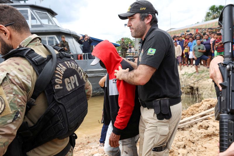 &copy; Reuters. Federal Police officers escort a man accused of being involved with the disappearance of missing British journalist Dom Phillips and indigenous expert Bruno Pereira, who went missing while reporting in a remote and lawless part of the Amazon rainforest, n
