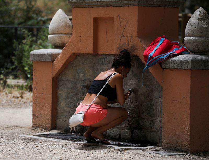 &copy; Reuters. Una mujer se refresca en una fuente de la Casa de Campo durante una ola de calor en Madrid, España. 15 de junio de 2022. REUTERS/Isabel Infantes