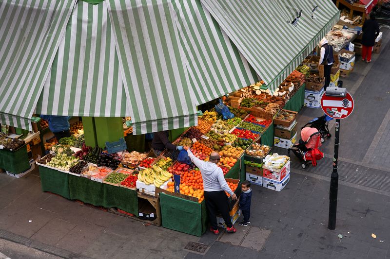 &copy; Reuters. FILE PHOTO: A man shops for fruit and vegetables at Brixton Market, amid the spread of the coronavirus disease (COVID-19) in London, Britain, September 27, 2020. REUTERS/Simon Dawson