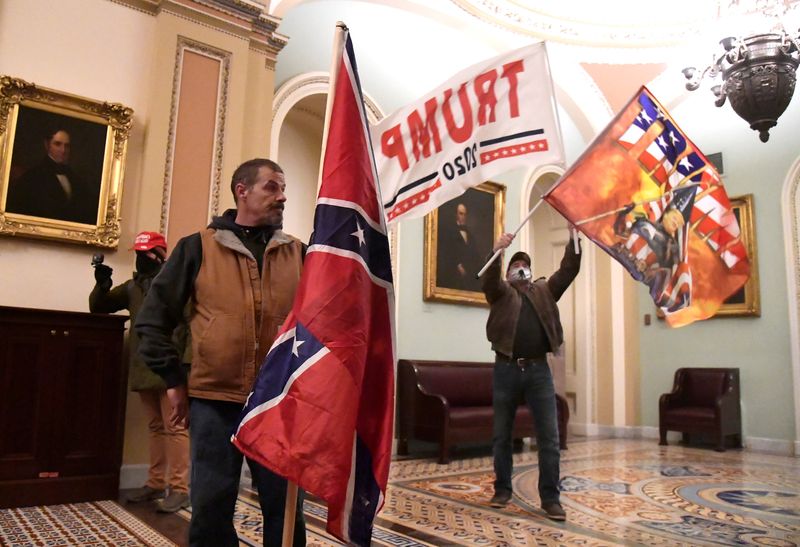 &copy; Reuters. FILE PHOTO: Supporters of U.S. President Donald Trump, including Kevin Seefried of Delaware holding the Confederate battle flag, demonstrate on the second floor of the U.S. Capitol near the entrance to the Senate after breaching security defenses, in Wash