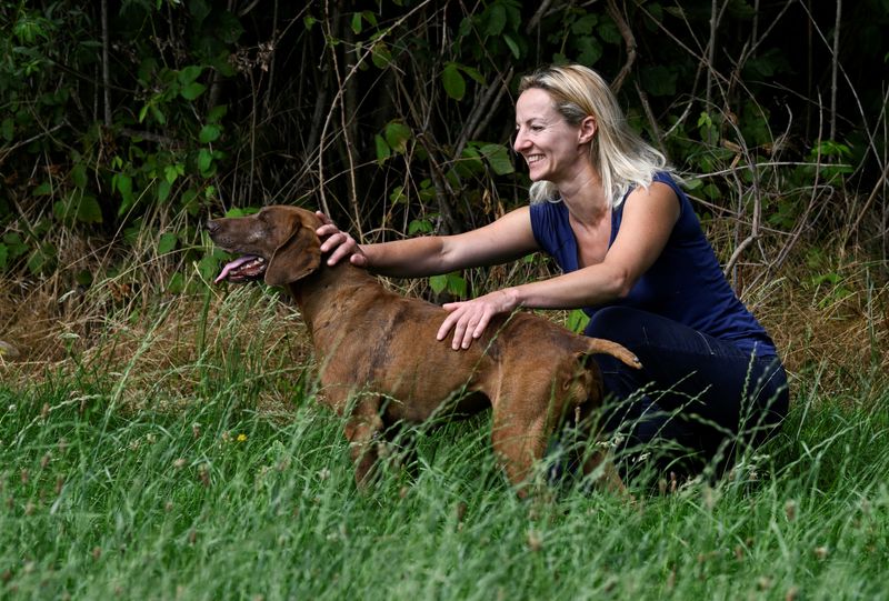 &copy; Reuters. Diana Parini, a woman who turned down a low-wage waitressing job at an Italian alpine resort, pets her dog in Morimondo, near Milan, Italy June 14, 2022. REUTERS/Flavio Lo Scalzo