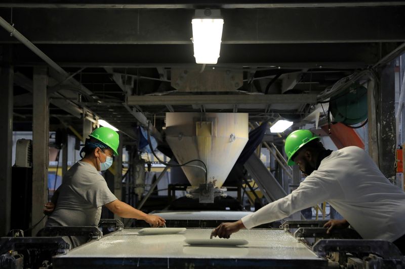 &copy; Reuters. FILE PHOTO: Workers trowel the poured mixture of a slab in the factory of IceStone, a manufacturer of recycled glass countertops and surfaces, in New York City, New York, U.S., June 3, 2021. REUTERS/Andrew Kelly/File Photo