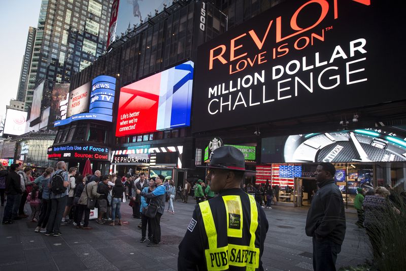 &copy; Reuters. FILE PHOTO: A Public Safety officer keeps watch as people stand in front of  a billboard owned by Revlon that takes their pictures and displays them in Times Square in the Manhattan borough of New York October 13, 2015.  REUTERS/Carlo Allegri