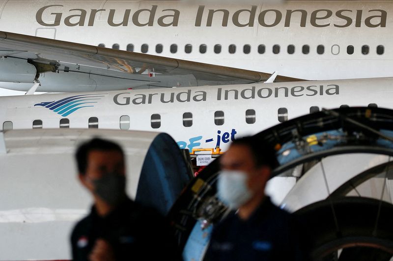 © Reuters. FILE PHOTO: Technicians walk as Garuda Indonesia's aircraft are parked for maintenances at the Garuda Maintenance Facility (GMF) AeroAsia, at Soekarno-Hatta International airport near Jakarta, Indonesia, January 21, 2022. REUTERS/Willy Kurniawan/File Photo