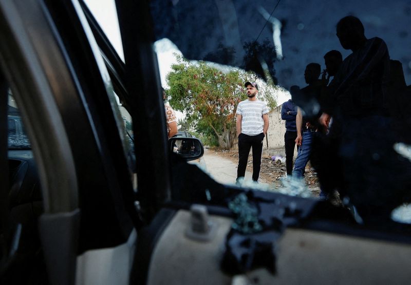 &copy; Reuters. Personas permanecen junto a un vehículo dañado tras una incursión israelí en Jenin, en la Cisjordania ocupada por Israel. 17 de junio de 2022. REUTERS/Mohamad Torokman