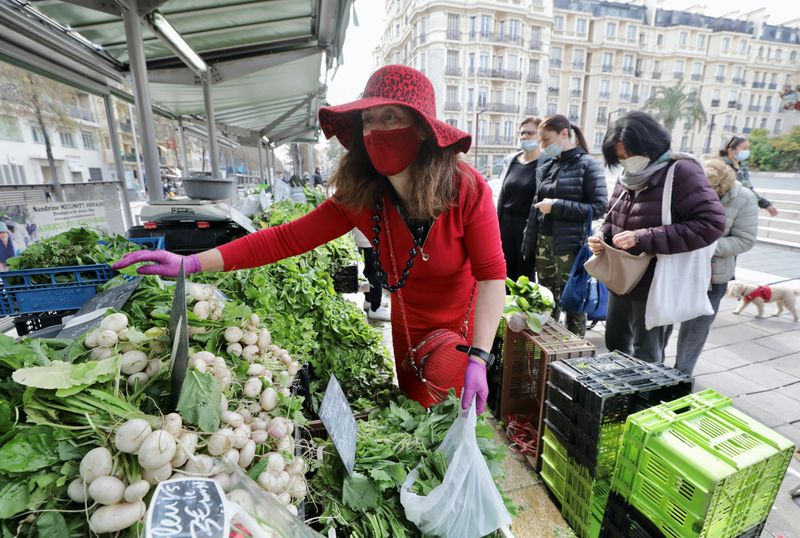 &copy; Reuters. FILE PHOTO: A vegetable seller, wearing a protective face mask, works on a local market amid the coronavirus disease (COVID-19) outbreak in Nice, France, March 4, 2021.   REUTERS/Eric Gaillard