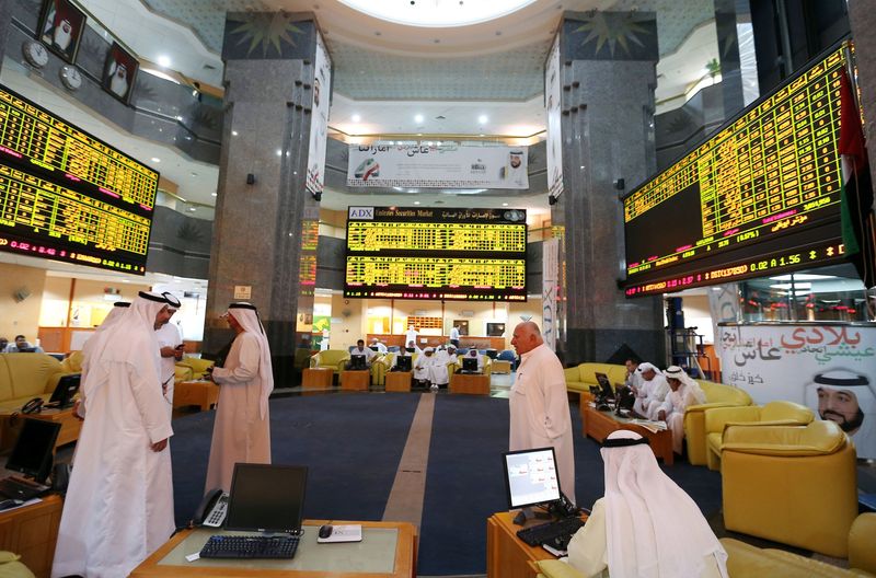 &copy; Reuters. متعاملون يتابعون حركة الأسهم على الشاشات الإلكترونية ببورصة أبو ظبي. تصوير رويترز