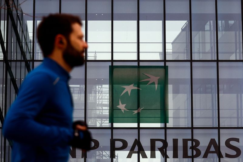 © Reuters. FILE PHOTO: A man walks past the logo of BNP Paribas at the bank's building in Issy-les-Moulineaux, near Paris, France, February 3, 2022. REUTERS/Gonzalo Fuentes