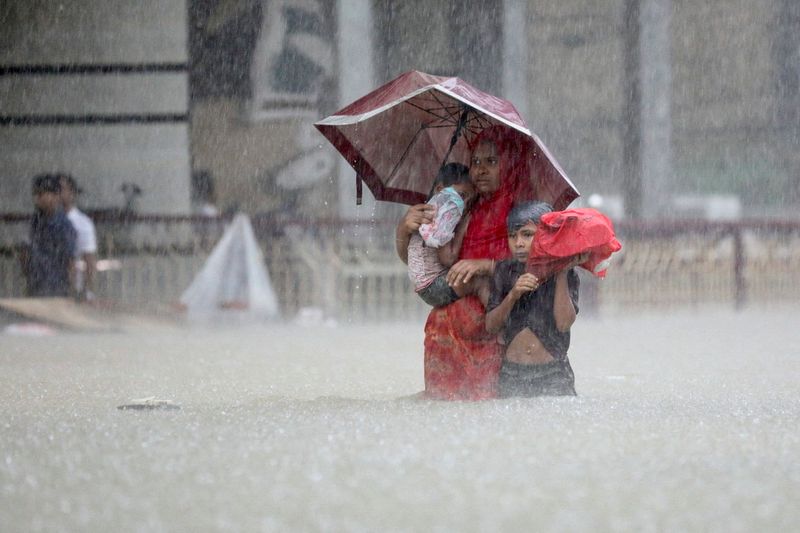 &copy; Reuters. عائلة في سيلهيت ببنجلاديش تخوض مياه الفيضانات بحثا عن مأوى وسط أمطار غزيرة تسببت في فيضانات واسعة النطاق في الجزء الشمالي الشرقي من البلاد 