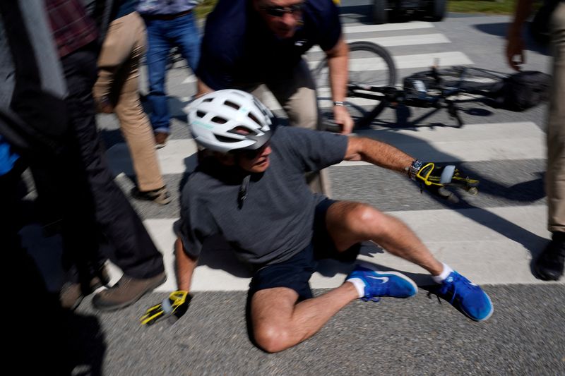 © Reuters. U.S. President Joe Biden falls to the ground after riding up to members of the public during a bike ride in Rehoboth Beach, Delaware, U.S., June 18, 2022. REUTERS/Elizabeth Frantz     