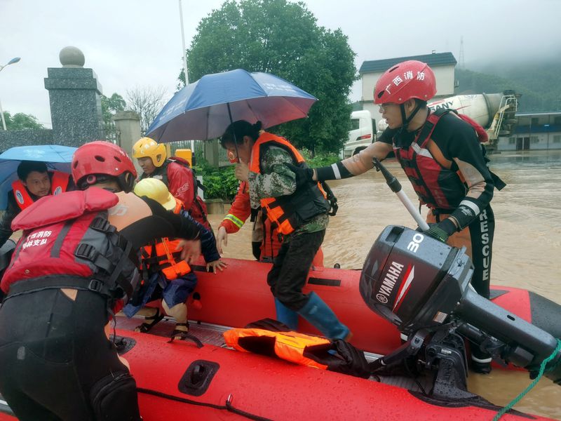 &copy; Reuters. أفراد إنقاذ يجلون أشخاصا تضرروا من الأمطار الغزيرة في قوانغشي يوم 17 يونيو حزيران 2022. صورة لرويترز (يحظر استخدام الصورة داخل الصين.)