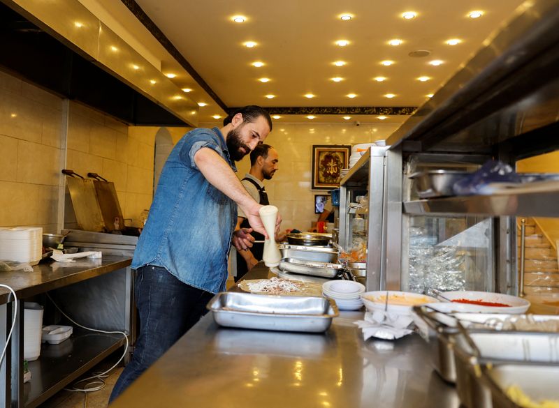 &copy; Reuters. اللاجئ السوري أنس قاطرجي يعمل في مطعمه الخاص في غزة يوم 16 يونيو حزيران 2022. تصوير: محمد سالم - رويترز.