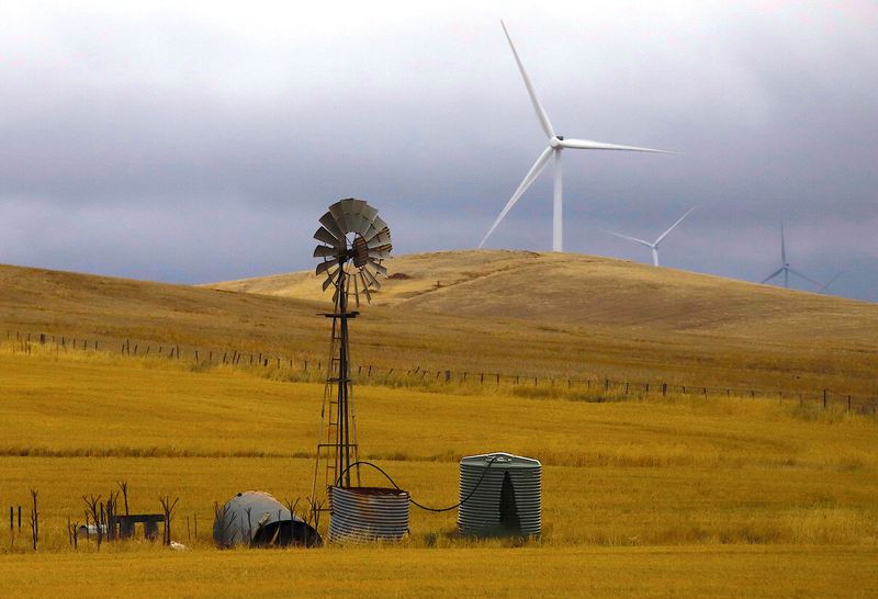 &copy; Reuters. FILE PHOTO: An old windmill stands in front of wind turbines in a paddock near the Hornsdale Power Reserve, featuring the world's largest lithium ion battery made by Tesla, located on the outskirts of the South Australian town of Jamestown, in Australia, 