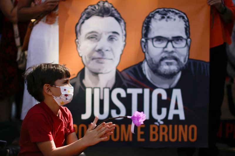 &copy; Reuters. Un niño sujeta una flor durante una protesta en Brasilia para exigir justicia por el asesinato del periodista británico Dom Phillips y el experto indígena en la Amazonia. 19 junio 2022. REUTERS/Ueslei Marcelino