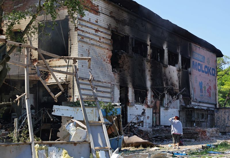 &copy; Reuters. Mulher caminha perto de mercado danificado por ataque de artilharia em Donetsk, na Ucrânia
19/06/2022 REUTERS/Alexander Ermochenko