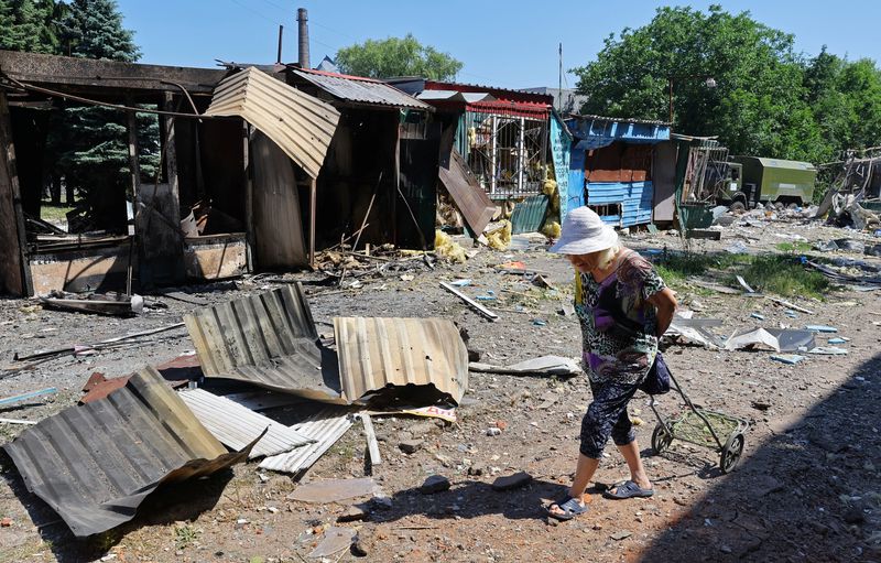 © Reuters. Pessoa passa por estruturas destruídas em um mercado local após bombardeio em Donetsk, Ucrânia June 19, 2022. REUTERS/Alexander Ermochenko