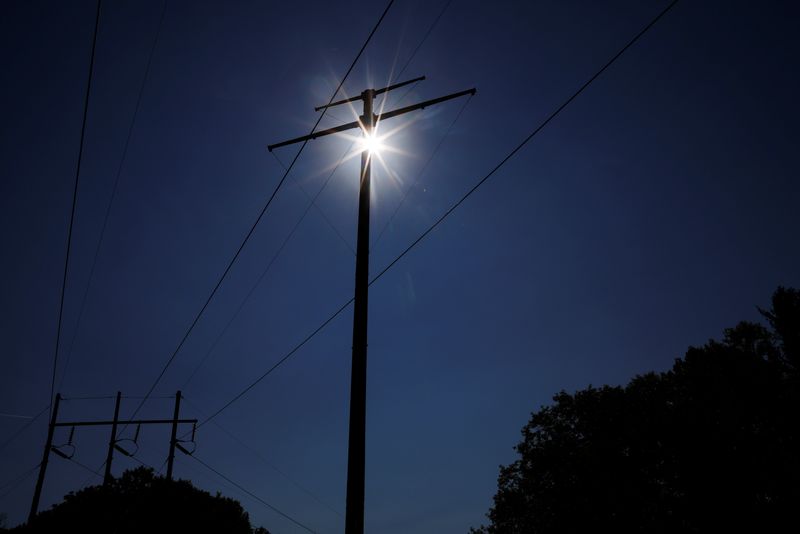 &copy; Reuters. FILE PHOTO: A newly installed pole for transmission lines for the New England Clean Energy Connect project (also known as the Clean Energy Corridor), which will bring hydroelectric power to the New England power grid, stand next to existing power lines in