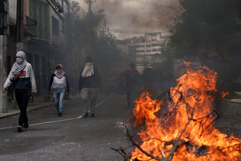 © Reuters. Protesters walk near a burning road blockade after Ecuador's armed forces warned they would not allow ongoing protests against President Guillermo Lasso's economic policies to damage the country's democracy, in Quito, Ecuador June 21, 2022. REUTERS/Santiago Arcos