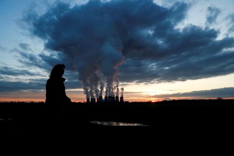 &copy; Reuters. FILE PHOTO: A woman walks a dog past Drax power station during the sunset in Drax, North Yorkshire, Britain, November 27, 2020. REUTERS/Lee Smith
