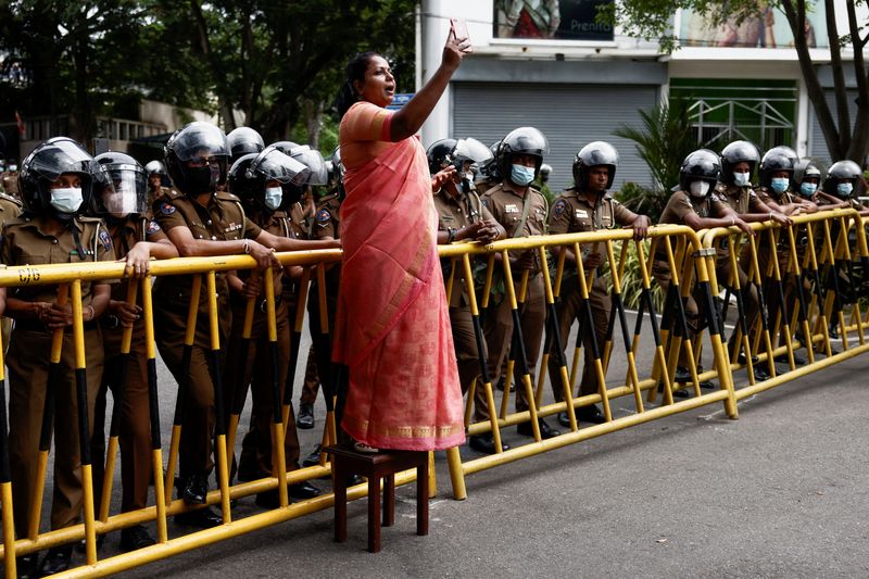 © Reuters. A member of Samagi Vanitha Balawegaya, a part of the main opposition party Samagi Jana Balawegaya, talks on live on social media during a protest near Sri Lanka's Prime Minister Ranil Wickremesinghe's private residence, in Colombo, Sri Lanka, June 22, 2022. REUTERS/Dinuka Liyanawatte