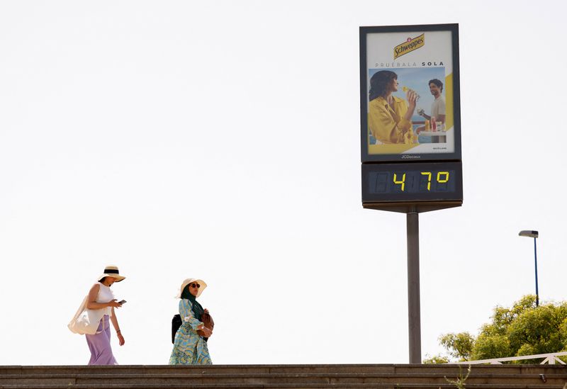 &copy; Reuters. امرأتان بجوار جهاز لقياس الحرارة يعرض درجة 47 مئوية في إشبيلية يوم 11 يونيو حزيران 2022. تصوير: مارسيلو ديل بوزو - رويترز