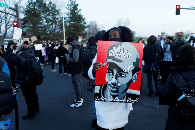&copy; Reuters. FILE PHOTO: A protester holds up a poster depicting Daunte Wright, as protests continue after former police officer Kim Potter fatally shot Daunte Wright, in Brooklyn Center, Minnesota, U.S. April 16, 2021. REUTERS/Octavio Jones/File Photo