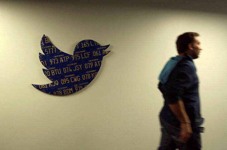 © Reuters. FILE PHOTO: An employee walks past a Twitter logo made from California license plates at the company's headquarters in San Francisco, California October 4, 2013. REUTERS/Robert Galbraith/File Photo