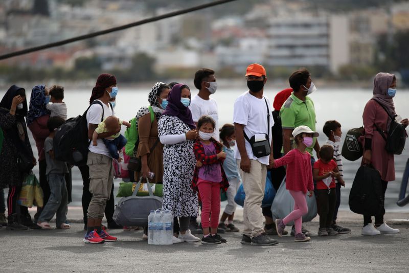 © Reuters. مجموعة من المهاجرين ينتظرون الصعود على متن سفينة لنقلهم إلى ميناء ميتلين بجزيرة ليسبوس في صورة من أرشيف رويترز. 