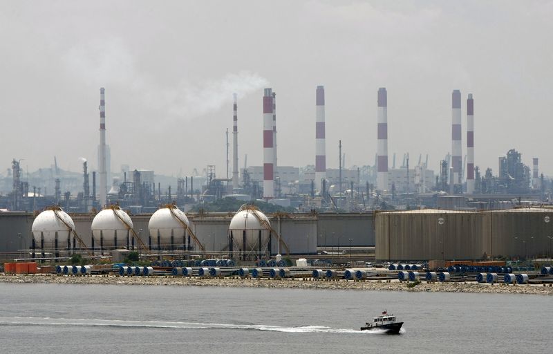 &copy; Reuters. FILE PHOTO: A boat passes in front of an oil refinery located on Singapore's Jurong Island March 28, 2009.  REUTERS/Vivek Prakash  