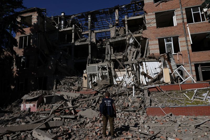 © Reuters. A worker from the war crimes prosecutor's office takes in the damage from overnight shelling that landed on a building of Kharkiv's Housing and Communal College as Russia's attack on Ukraine continues in Kharkiv, Ukraine, June 21, 2022. REUTERS/Leah Millis