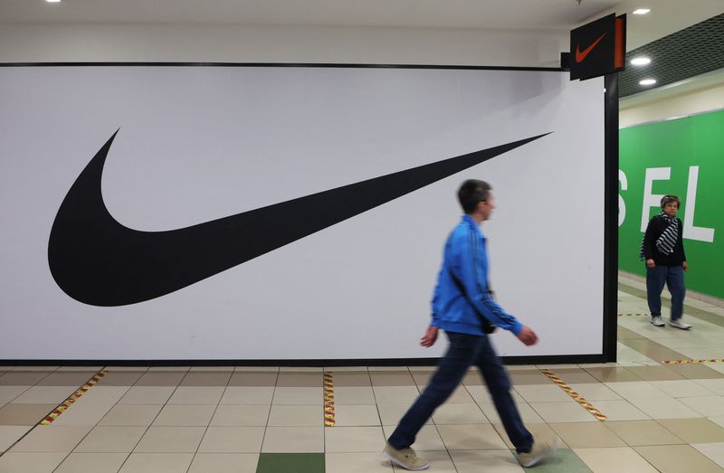 &copy; Reuters. Dos personas pasan junto a una tienda cerrada de Nike en un centro comercial de San Petersburgo, Rusia.