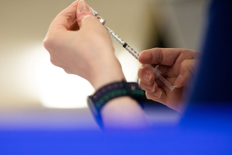 &copy; Reuters. FILE PHOTO: A nurse fills up syringes with the coronavirus disease (COVID-19) vaccines for residents who are over 50 years old and immunocompromised and are eligible to receive their second booster shots in Waterford, Michigan, U.S., April 8, 2022.  REUTE