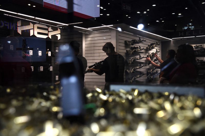 © Reuters. FILE PHOTO: An attendee tries out a gun on display at the National Rifle Association (NRA) annual convention in Houston, Texas, U.S. May 28, 2022. REUTERS/Callaghan O'Hare