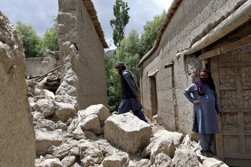 &copy; Reuters. أفغانيان يقفان على أنقاض منزلهما يوم 23 من يونيو حزيران 2022 الذي لحقه الدمار جراء الزلزال في جايان بأفغانستان. تصوير: على كارا - رويترز 