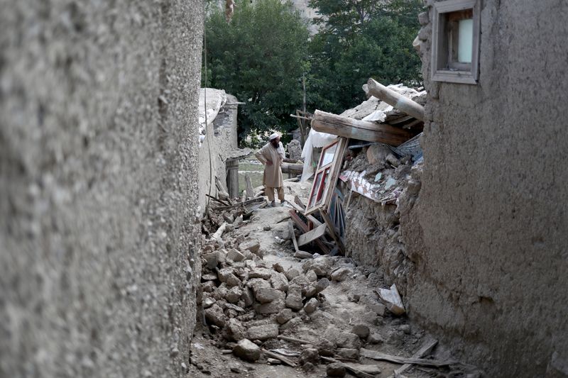 &copy; Reuters. أفغاني يقف يوم الخميس بين منازل لحقها الدمار جراء زلزال ضرب منطقة جايان في أفغانستان. تصوير: علي كارا - رويترز 